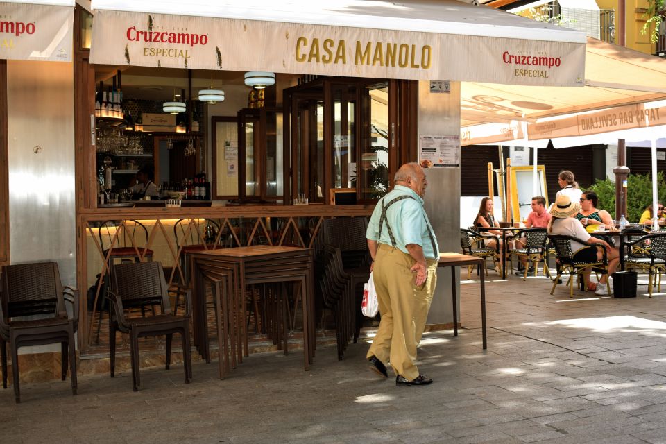 Seville: Tapas, Taverns, and History Walking Tour - Stop 1: The early-1900s tavern and flaming chorizo